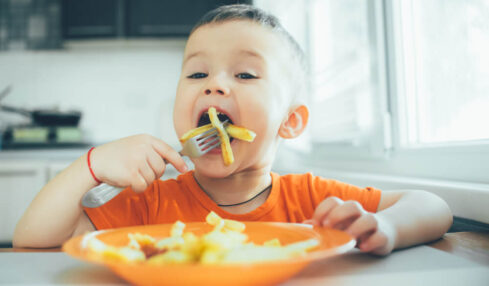 Ребенок есть картошку-фри